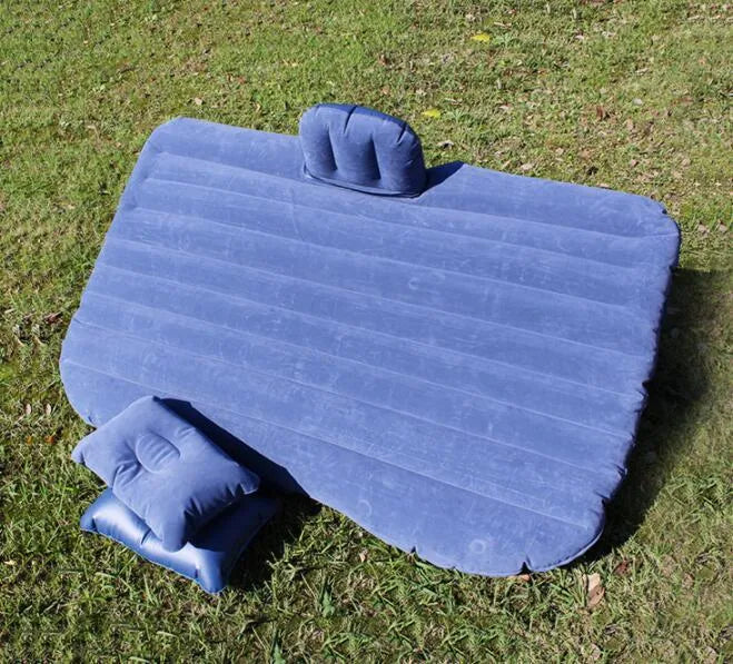 Universal inflatable car bed with flocked surface and pillows laid out in a car boot.