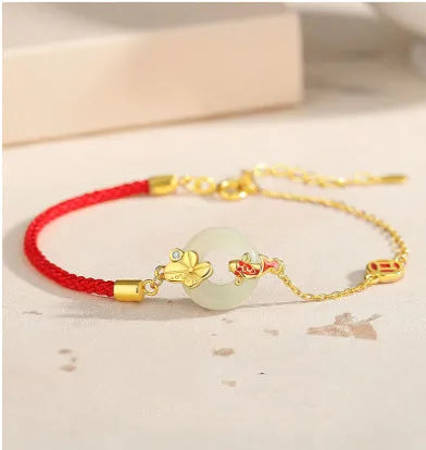 Women's silver bracelet with gold koi design and red rope adjustment