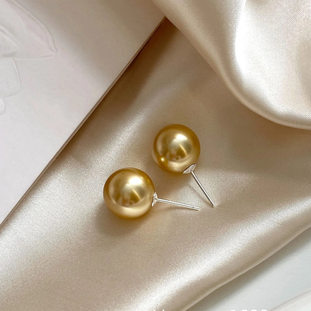 Geometric pearl stud earrings with eight-pointed star design in silver setting