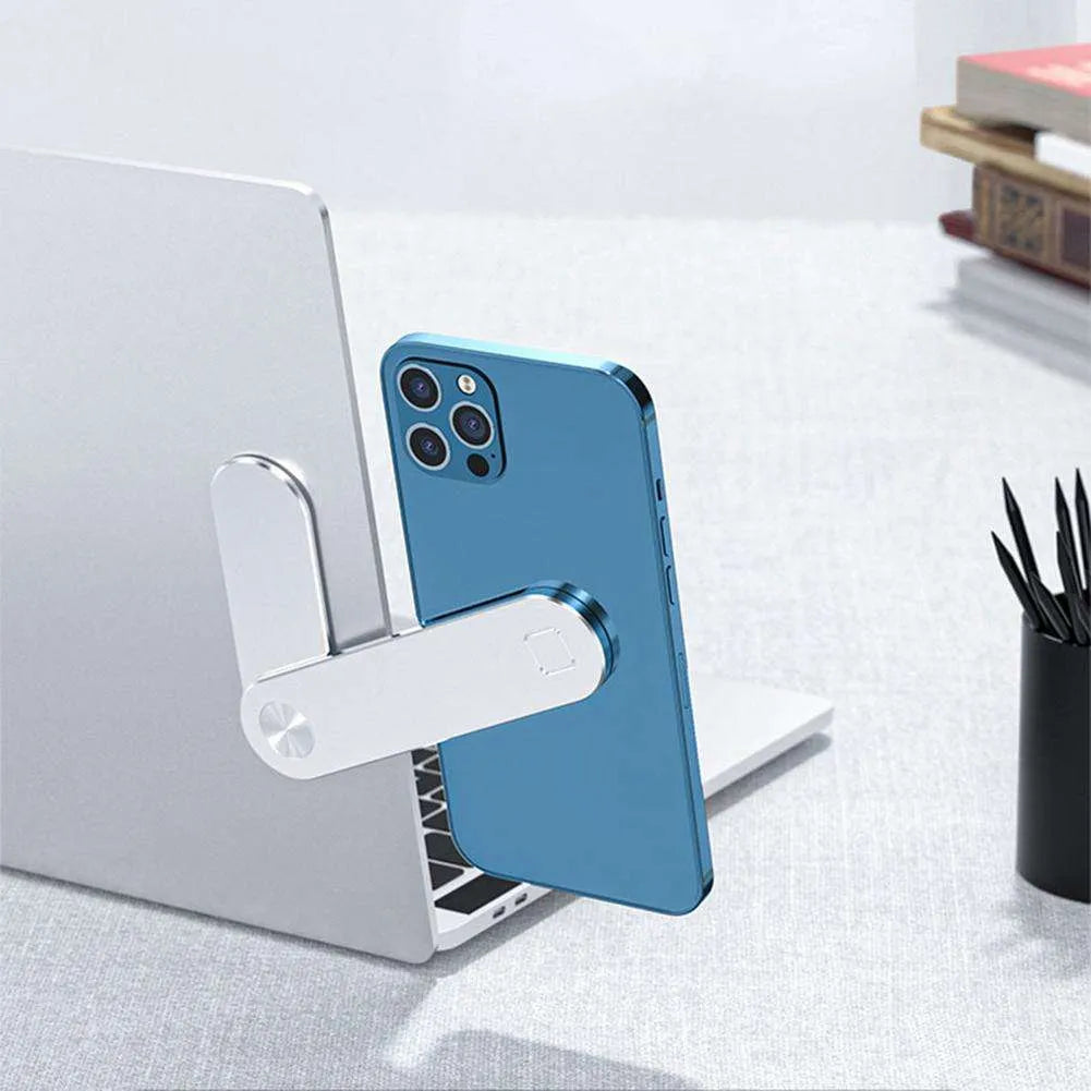 Black adjustable magnetic phone holder clipped to silver laptop showing phone mounted beside screen