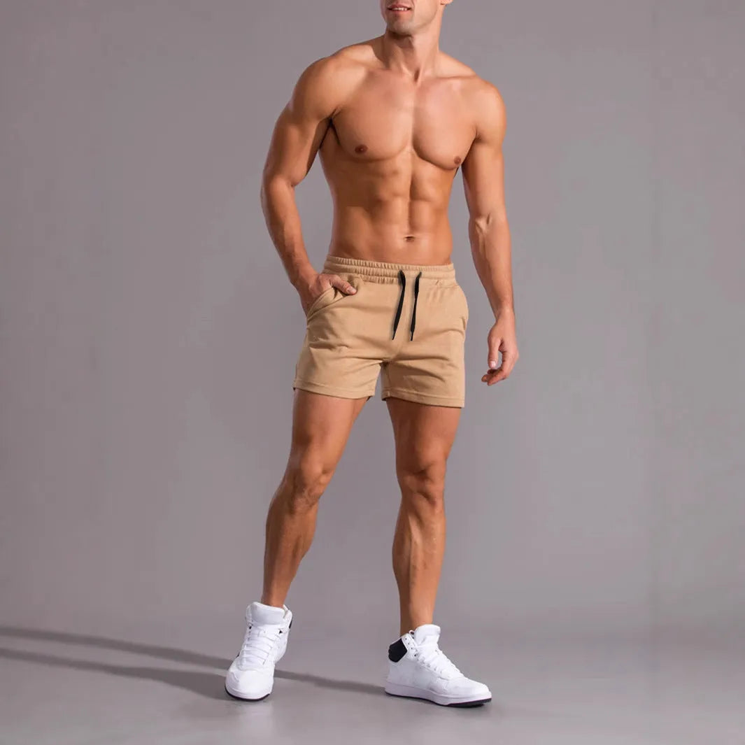 Three pairs of men's solid-colour loose fit shorts with drawstring waists, shown in black, khaki, and light brown.