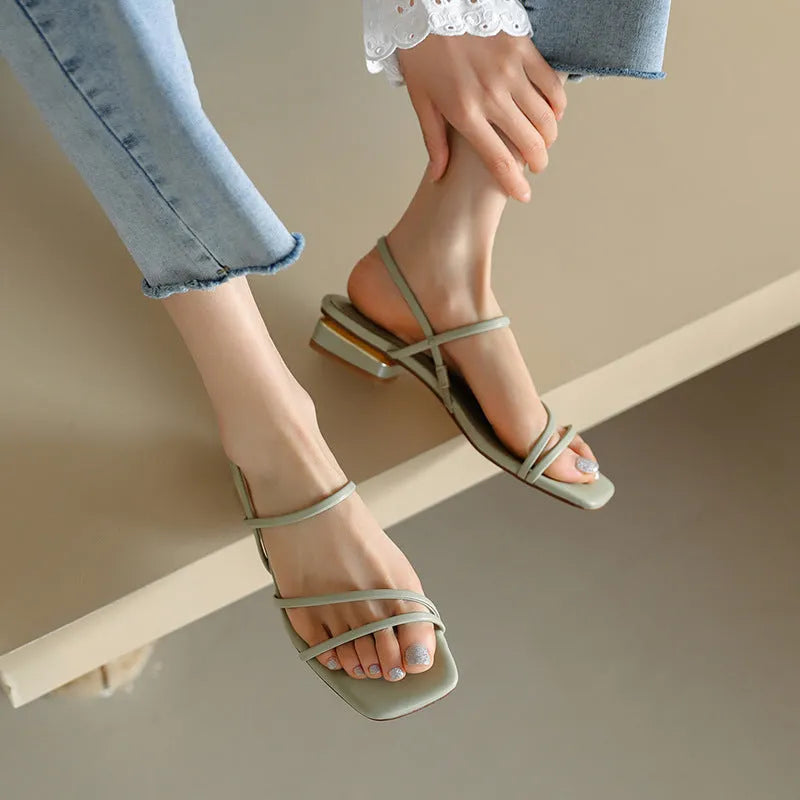 Women's green flat Roman sandals with square toe and microfiber straps on a white background.