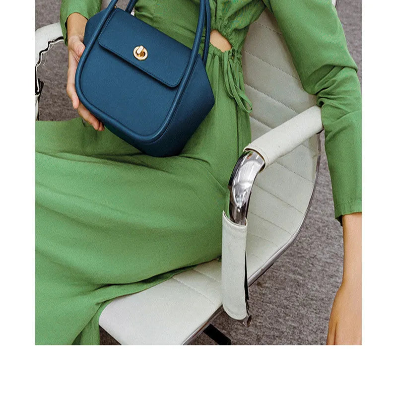 Soft cow leather wing-shaped tote handbag with a buckle latch and single cross-body shoulder strap.