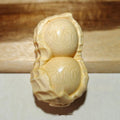 Solid natural bamboo carving peanut ornament on a neutral background