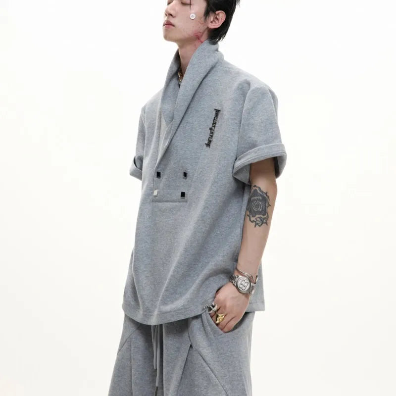 Men's dark grey cotton sports suit with V-neck jacket featuring padded shoulders and metal details, worn with matching shorts