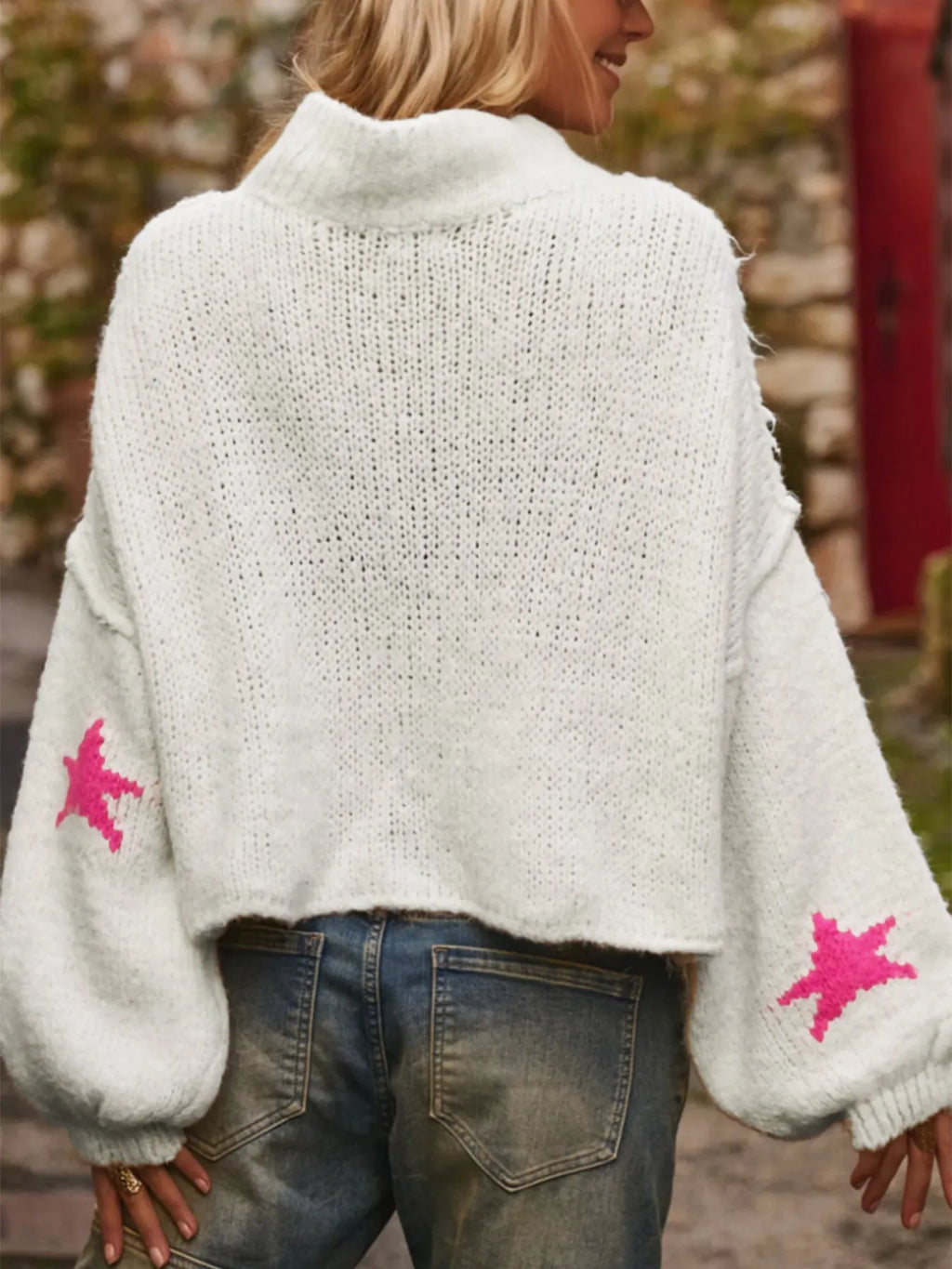 White loose women's turtleneck pullover with a black five-pointed star pattern on the front.