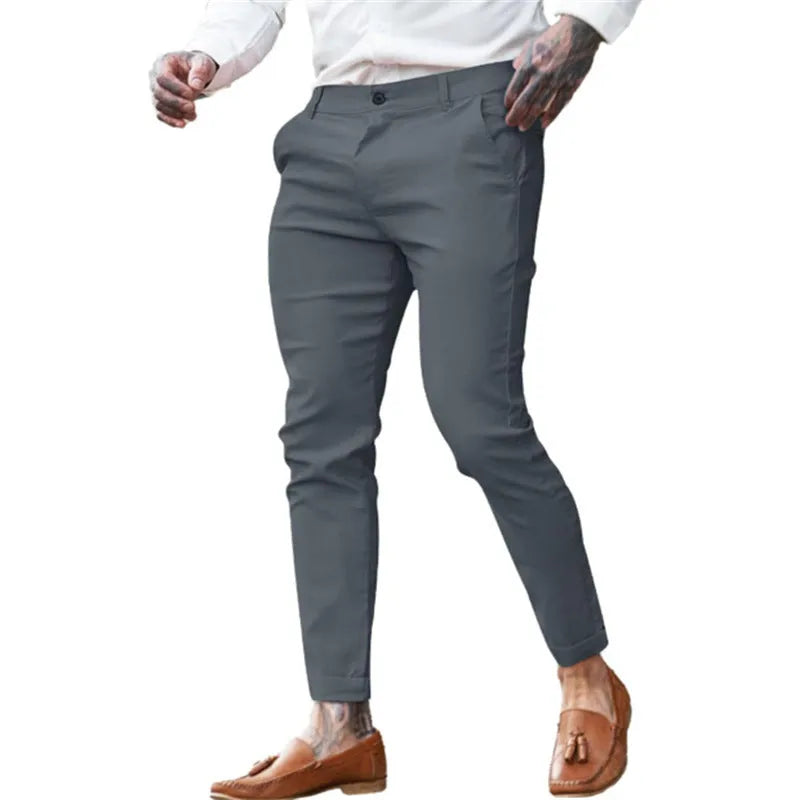 Men's slim pencil trousers in stretch cotton twill fabric on a hanger, showing the mid waist and slim leg cut.