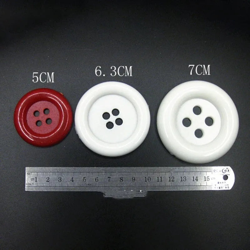 Oversized plastic nylon buttons in multiple colours with round edges and four stitching holes