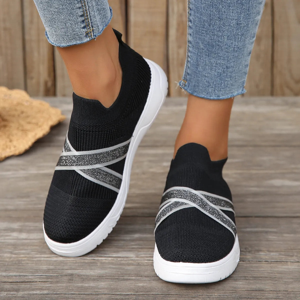 Women's black casual shoes with fabric mesh upper and flat rubber sole on neutral background