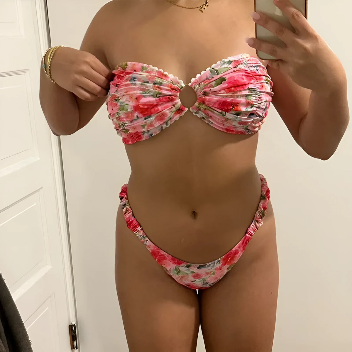Women's floral print tube top bikini set with lace trim on a blue background.