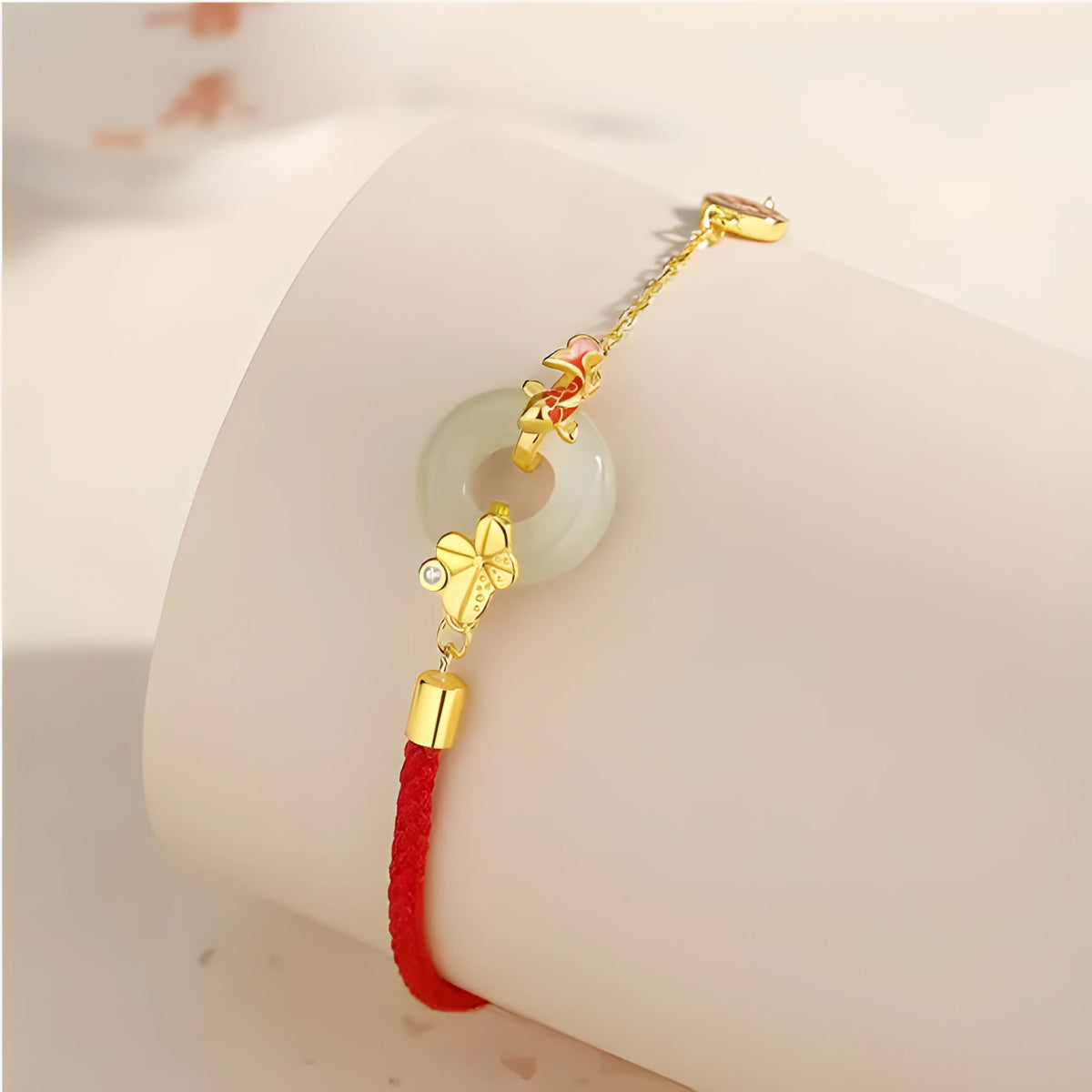 Women's silver bracelet with gold koi design and red rope adjustment