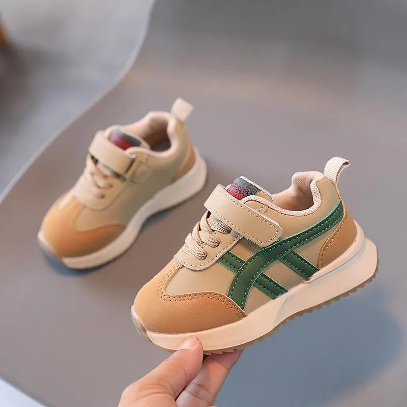 Children's solid colour sneaker with Velcro strap fastening, shown in beige with a rubber sole.