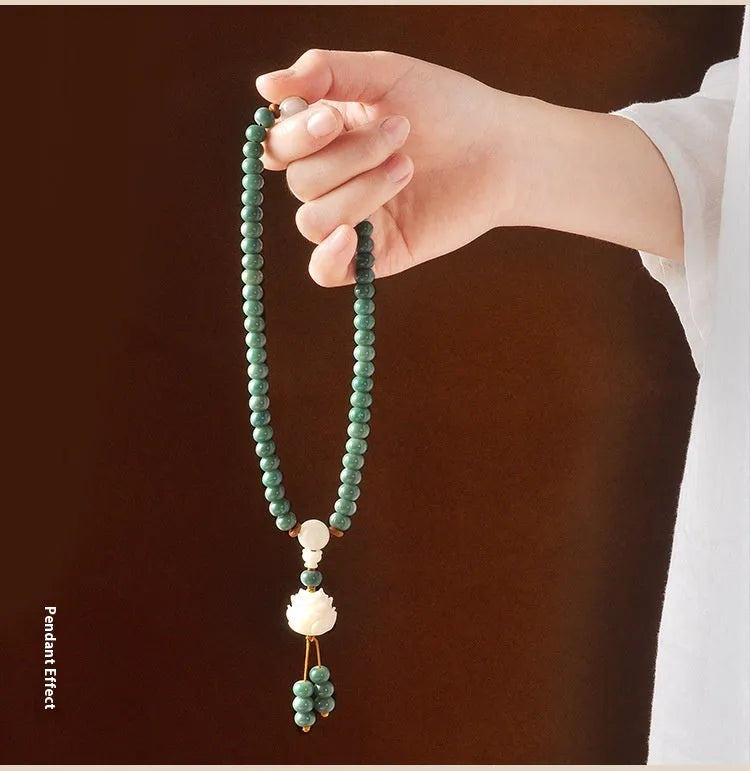 White jade and green sandalwood beaded bracelet with a double ring lotus safety buckle clasp.