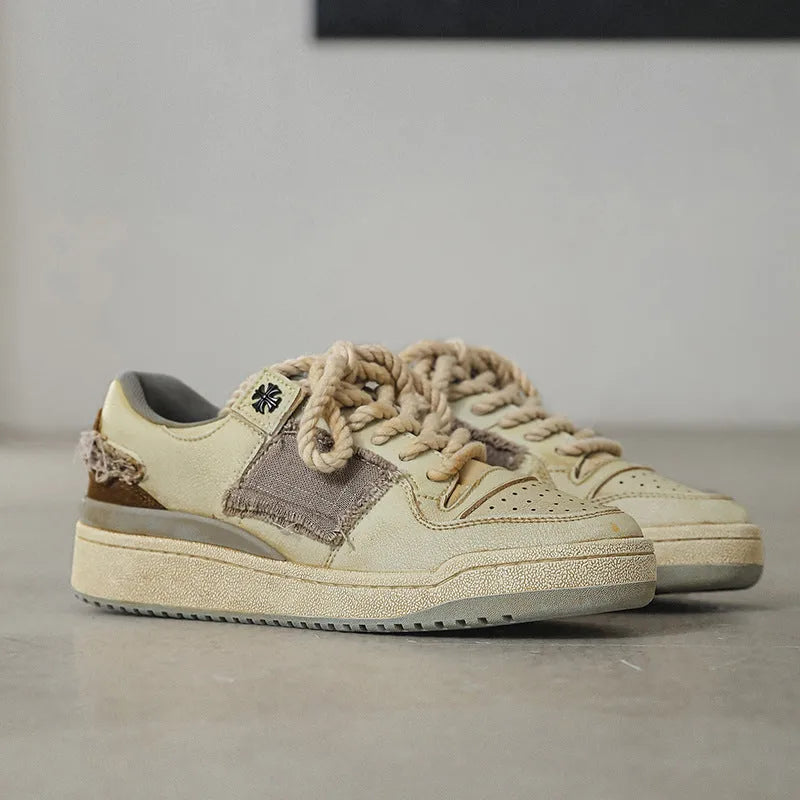 Beige low-top vintage style skateboard shoes with round toe and lace-up front on a rubber sole.