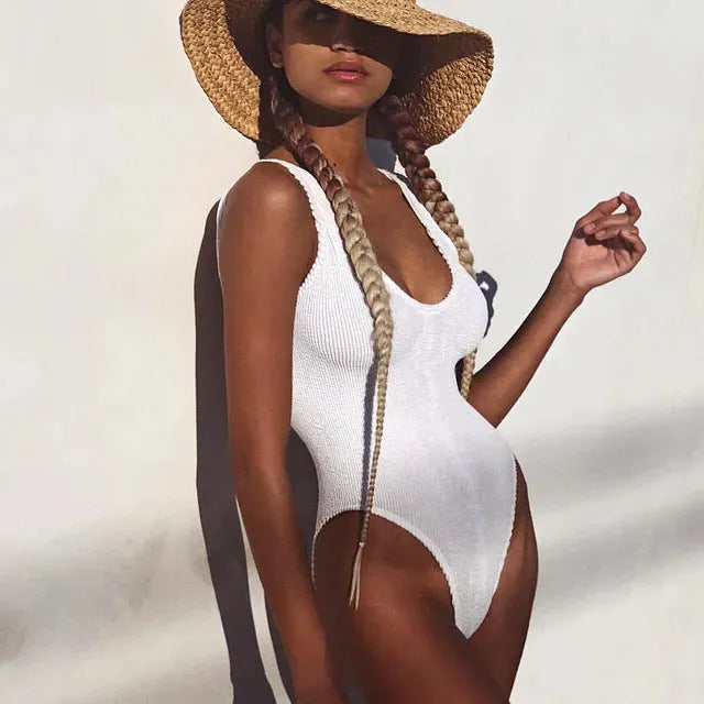Solid colour seersucker one-piece swimsuit in a sleeveless, backless design on a mannequin.