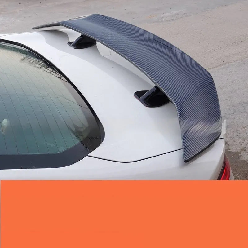 Universal fit car tail wing spoiler with punch-free mounting in carbon pattern finish.