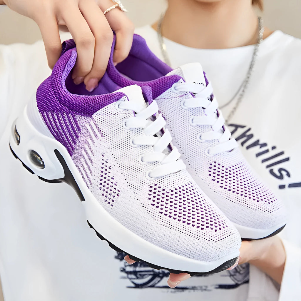 Women's pink Flyknit running shoes with a striped pattern, flat PVC sole, and lace-up front.
