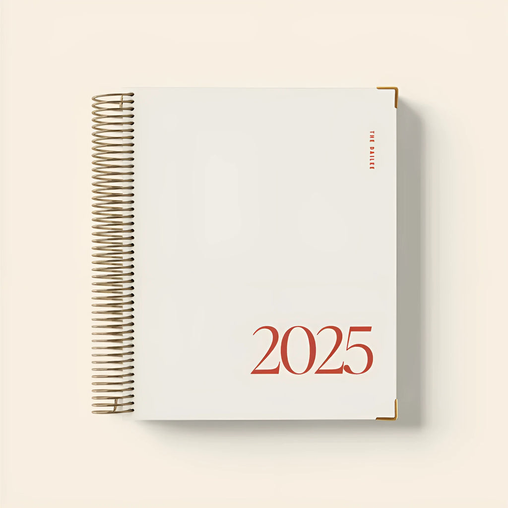 Cherry red daily schedule coil notebook open to show wire-o binding and planner layout.