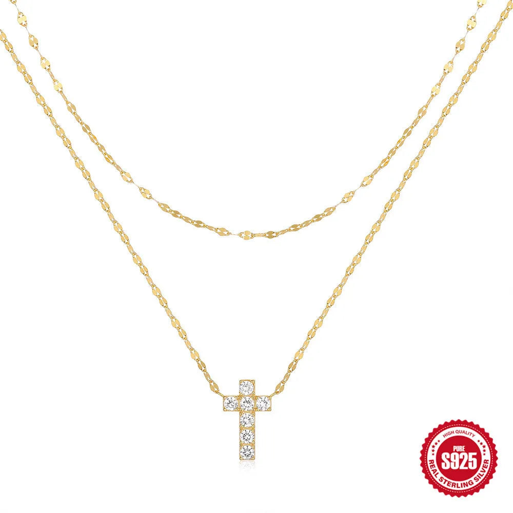 Close-up of a sterling silver double-layer geometric cross pendant on a clavicle chain.