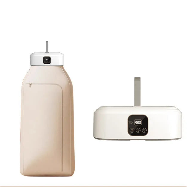 White cylindrical compact electric clothes dryer with remote control on a table.