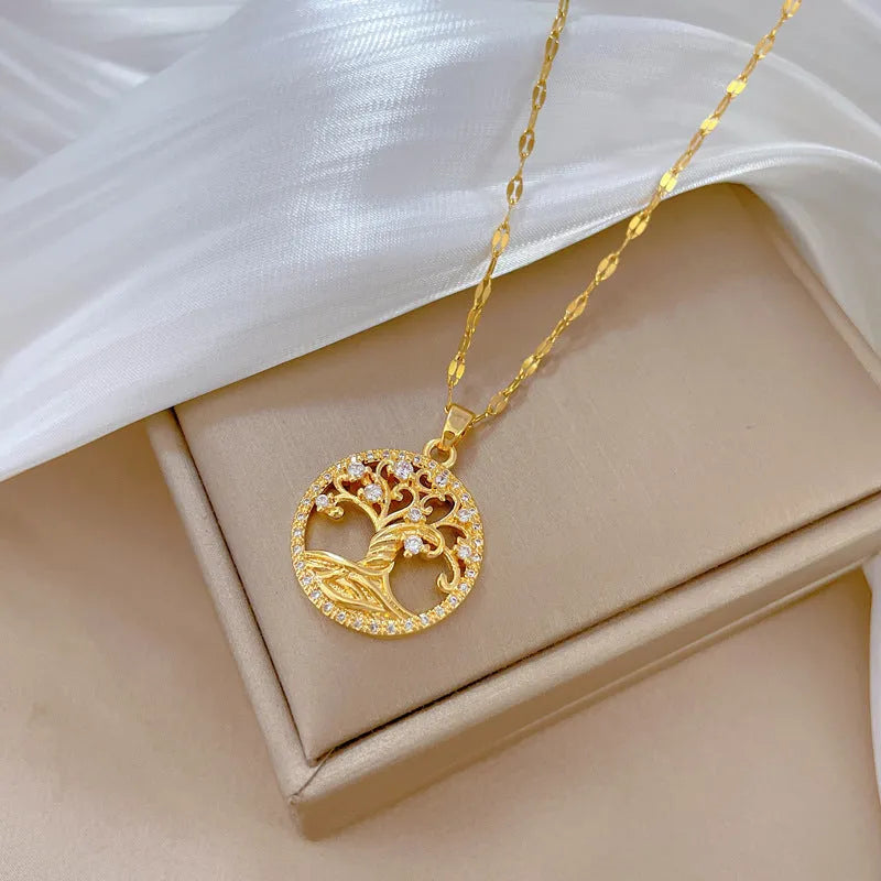 Gold-plated necklace with rhinestone tree pendant featuring mother-of-pearl detail on adjustable lip chain