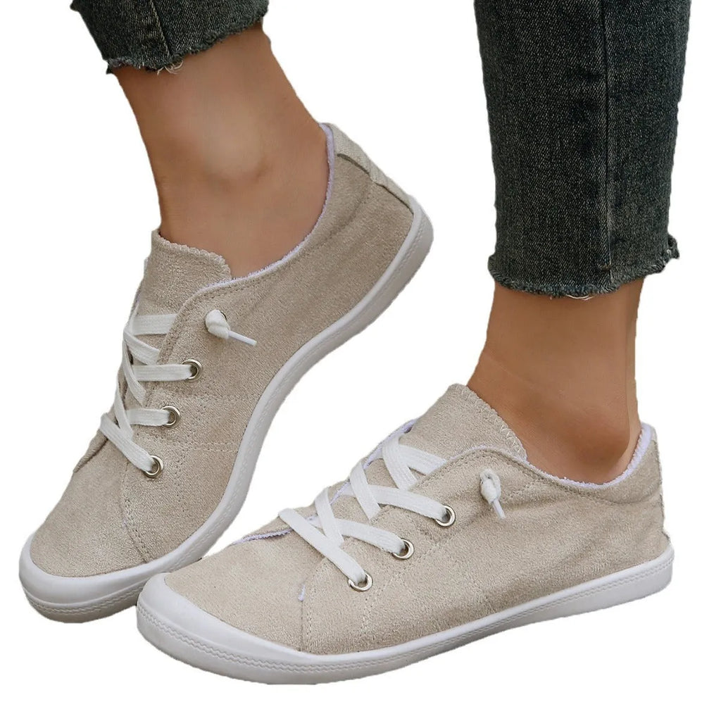 Women's creamy-white low-top fabric sneaker with rubber sole shown from side view