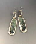 A pair of silver and grey geometric drop earrings with a marble stone pattern on a white background.
