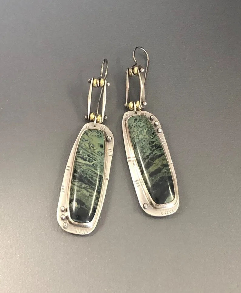 A pair of silver and grey geometric drop earrings with a marble stone pattern on a white background.