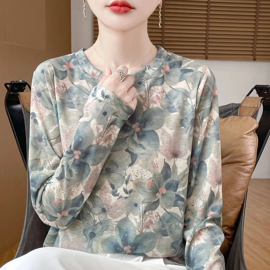 Floral print round neck pullover in knitted Tencel cotton fabric on a hanger.