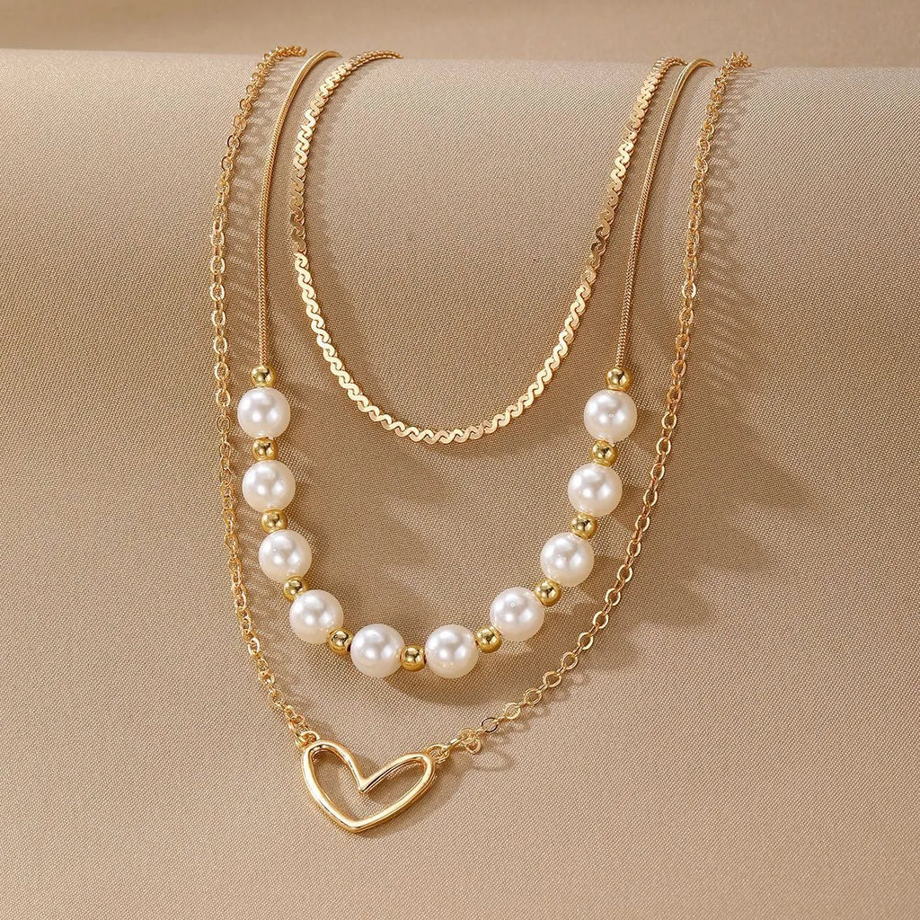 Vintage gold necklace with heart-shaped pendant and pearl chain design