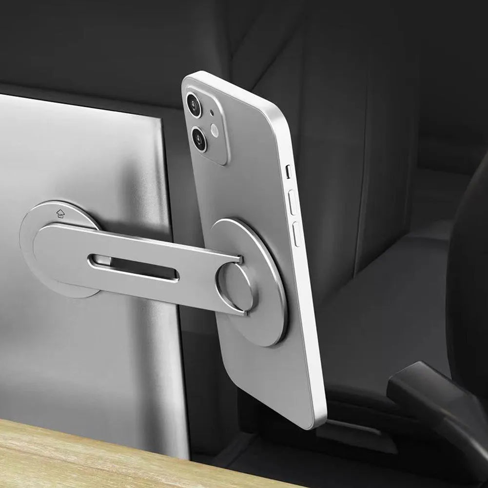 Silver aluminium alloy magnetic phone holder for car, shown mounted next to a Tesla-style screen.