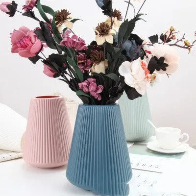 Colourful melamine plastic decorative flower vase on a tabletop.