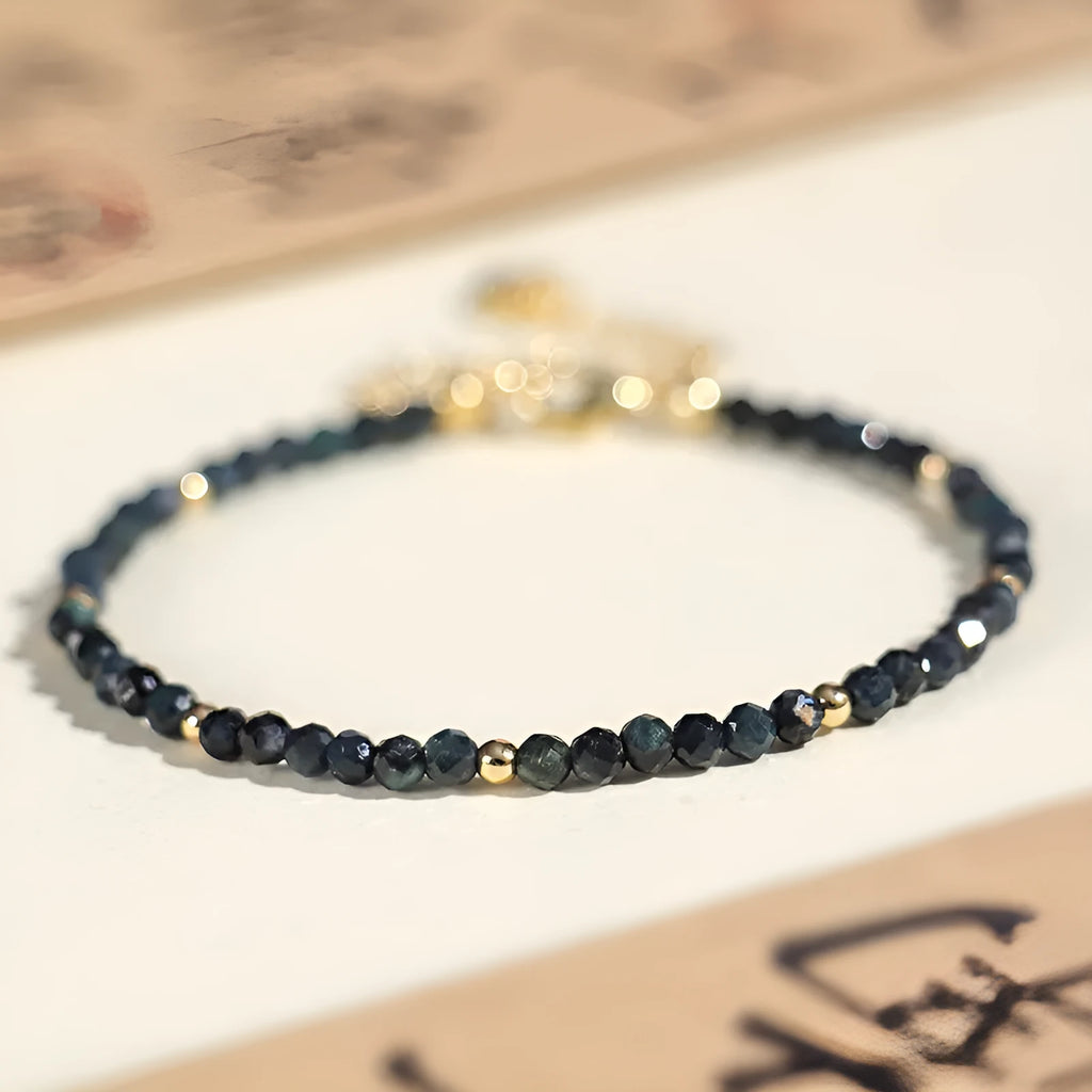 Adjustable blue tourmaline beaded bracelet with spacer beads and gold-colour accents on a wrist.