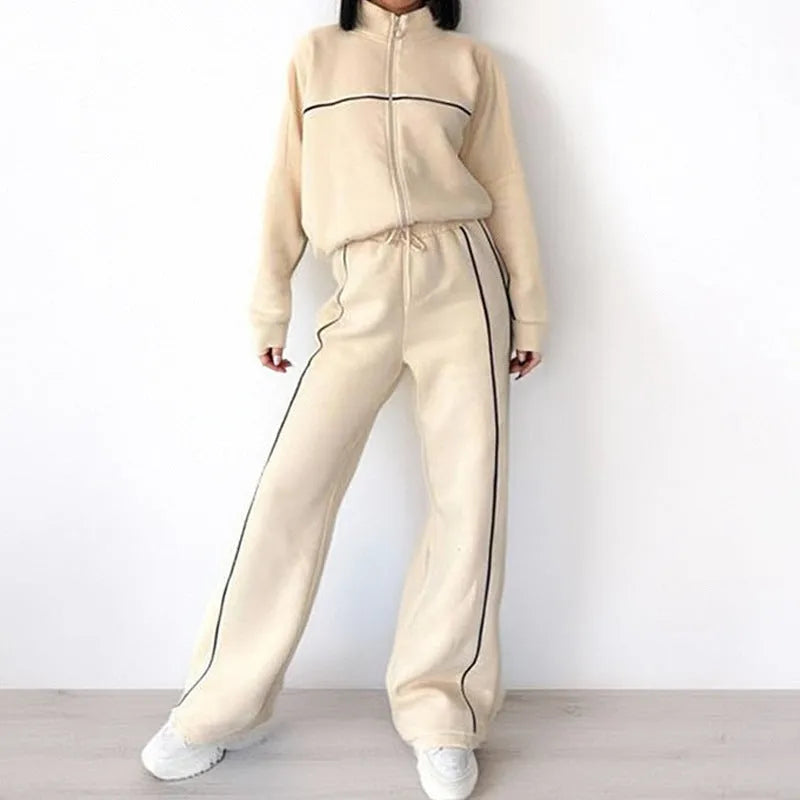Casual two-piece suit set with a mock neck zip hoodie and striped trousers on a hanger.