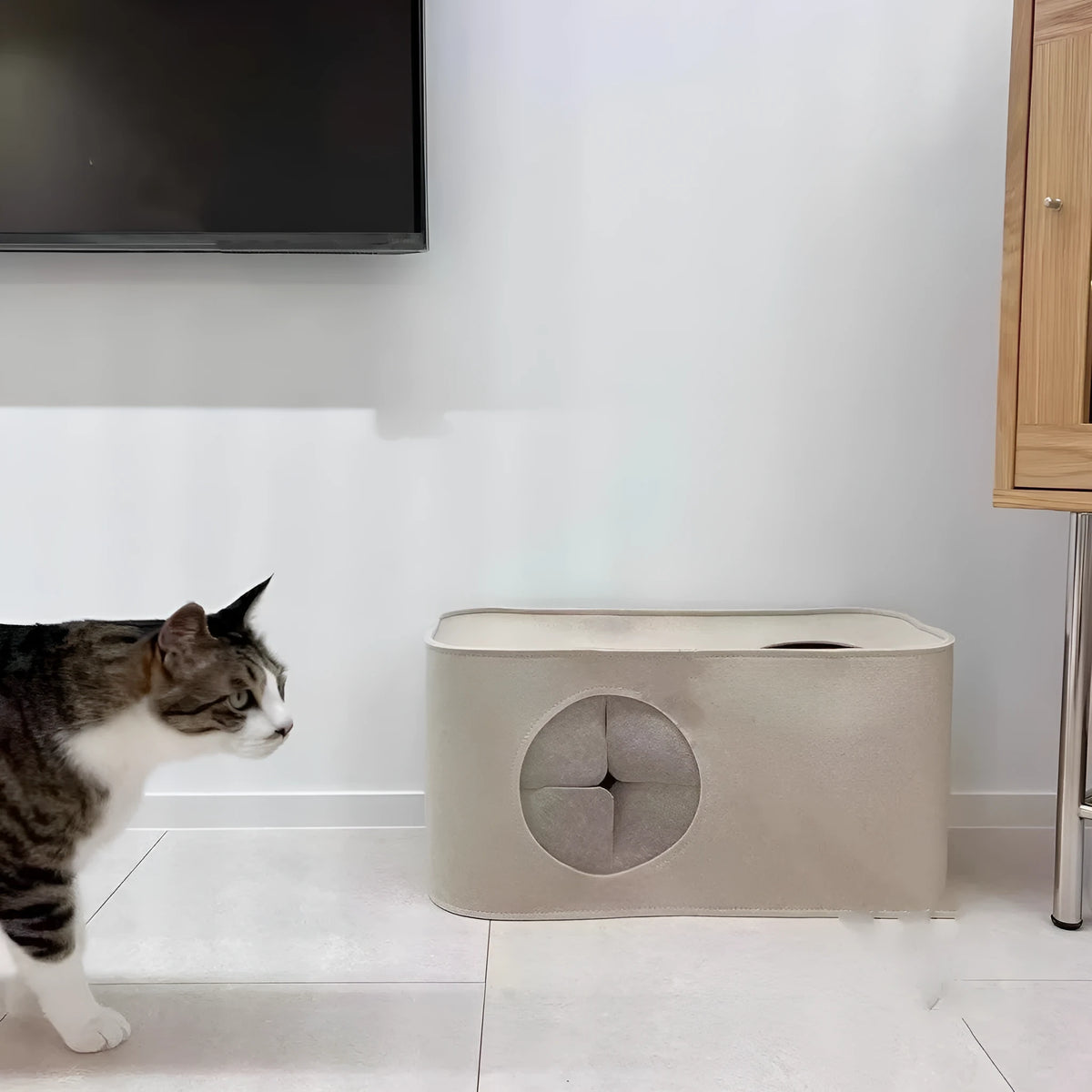 Foldable grey felt cat nest bed shown in a home setting, with a cat resting inside.