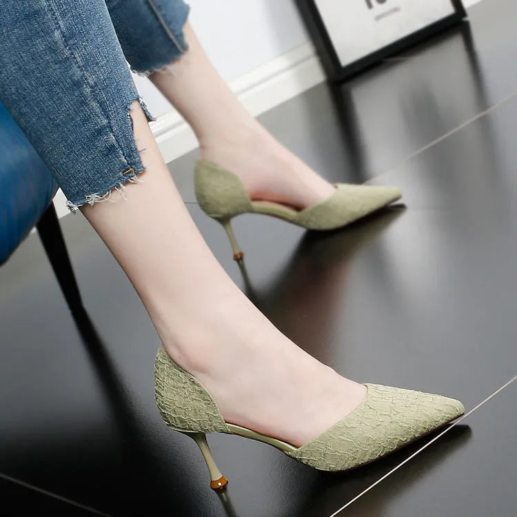 Women's black pointed toe stiletto high heel shoes on a plain background.