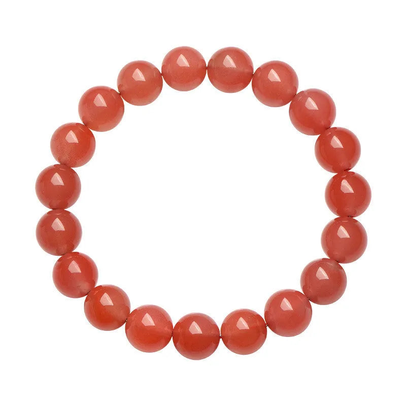 Loose polished cherry red agate beads in various sizes for bracelet making on a white surface.