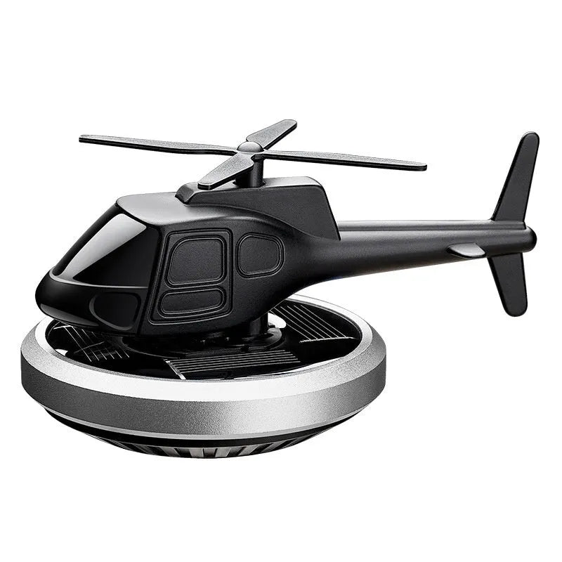Silver solar powered rotating helicopter car perfume ornament on vehicle dashboard