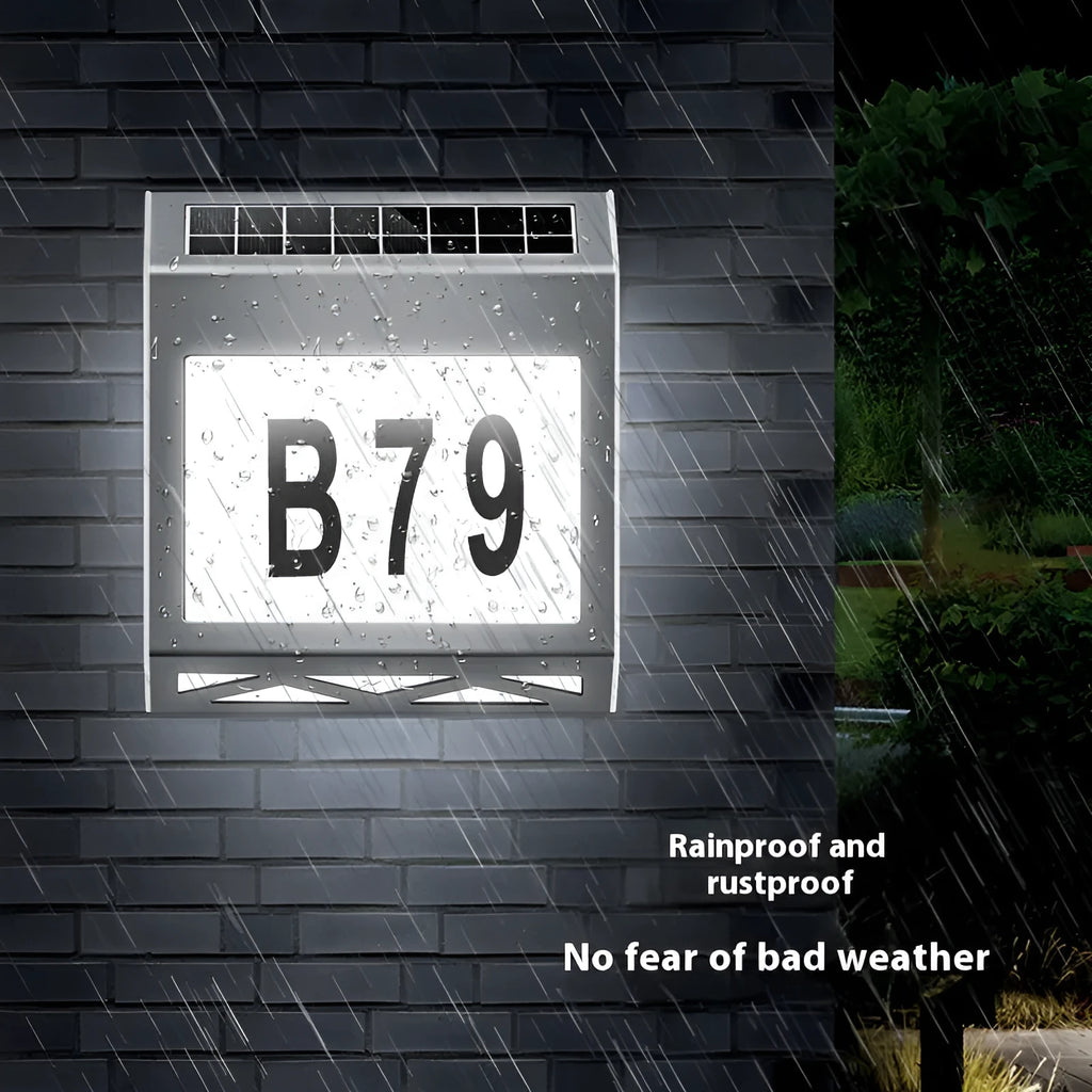 Black solar-powered outdoor doorplate light with digital LED number display mounted on a wall