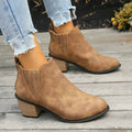 Women's black ankle boots with pointed toes and thick square heels on a solid background
