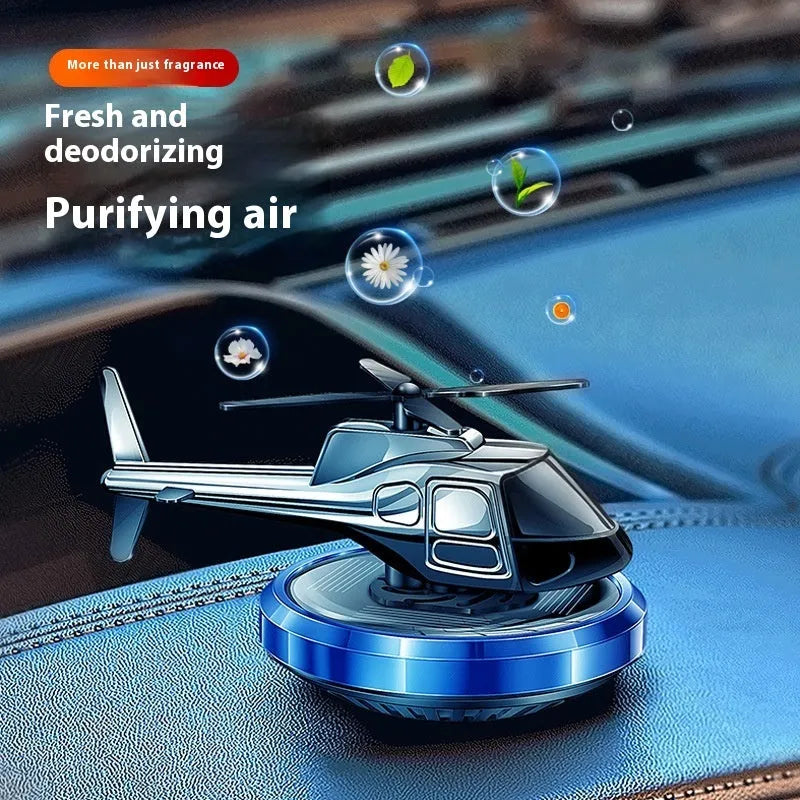 Silver solar powered rotating helicopter car perfume ornament on vehicle dashboard