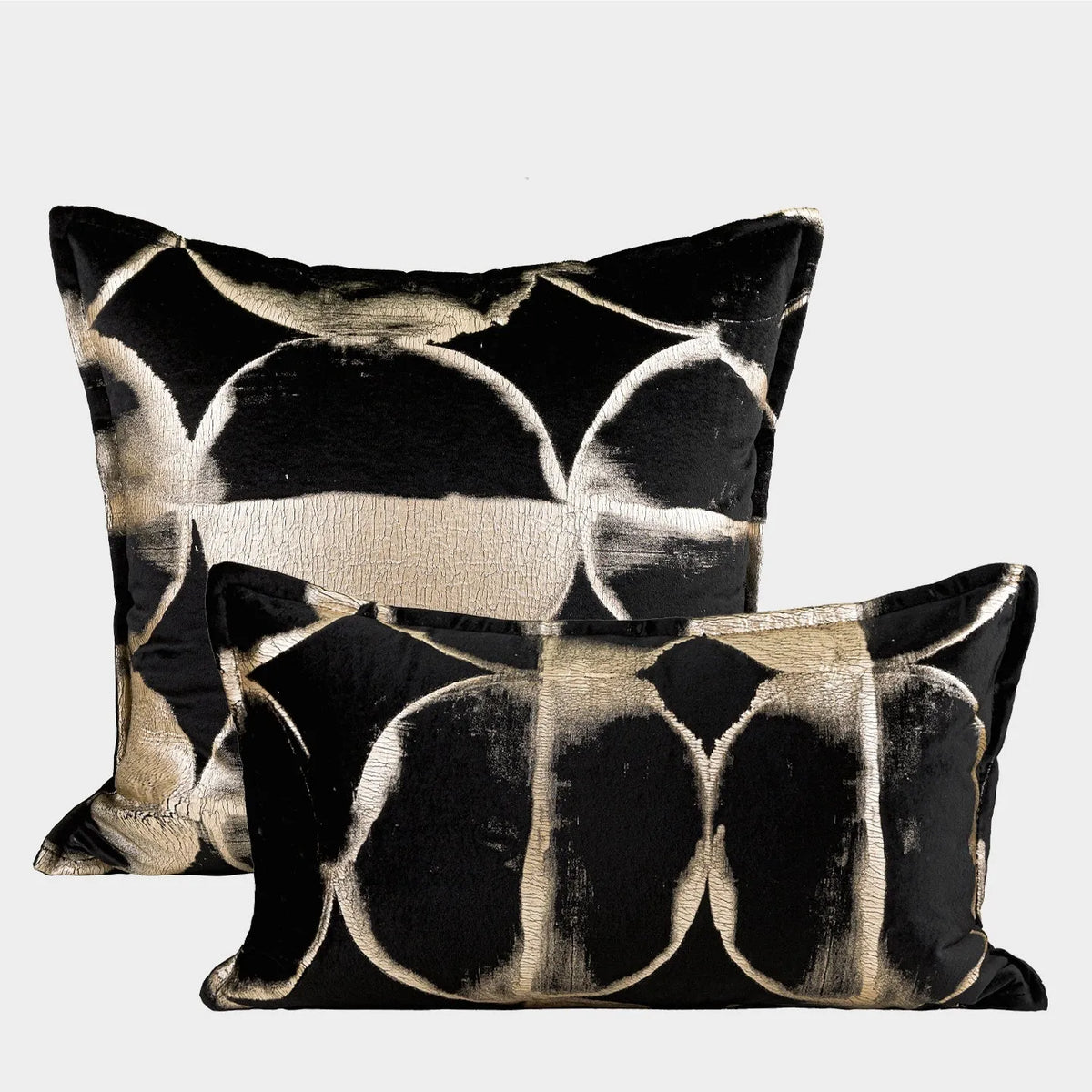 Black and gold abstract pattern square cushion with removable feather velvet cover on a sofa.