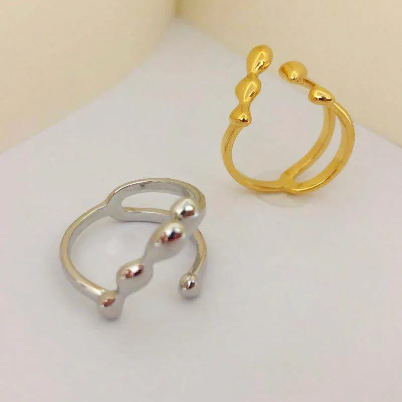 Adjustable brass opening ring with spherical detail in gold or silver colour
