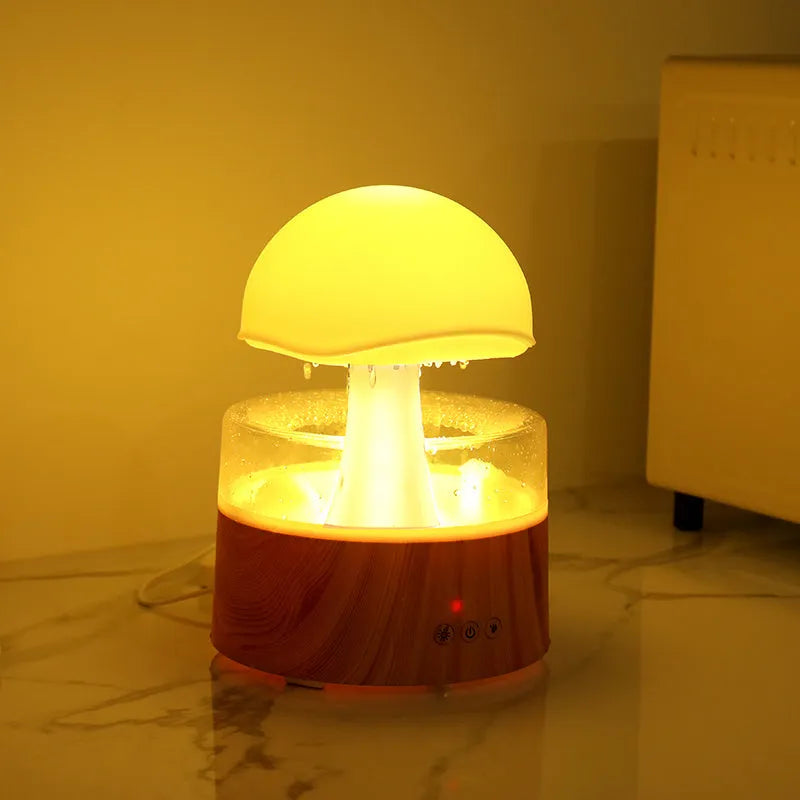 White cloud-shaped humidifier and aroma diffuser with simulated raindrops and coloured night light