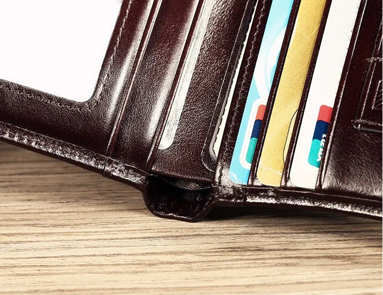 Men's brown leather wallet open to show card slots, ID window, coin pocket, and banknote fold.