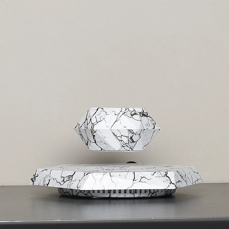 Small marble-colour plastic plant pot floating above a magnetic base unit.