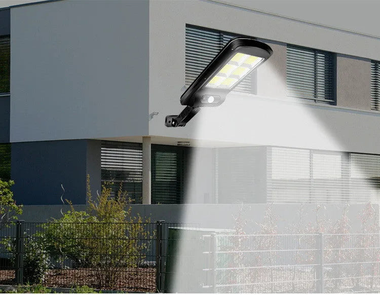 Black outdoor solar motion sensor security light mounted on a wall or fence post.