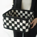 Checkerboard patterned woven felt storage basket folded flat next to it assembled