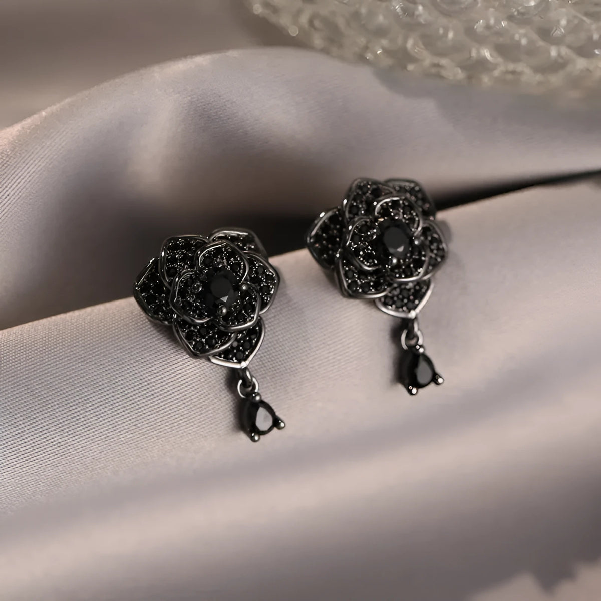 Pair of women's black rose zircon floral stud earrings on electroplated 18K copper.