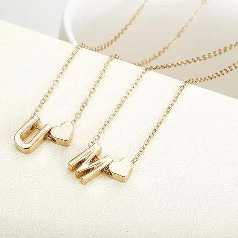 Peach heart shaped letter necklace pendant in gold alloy on display
